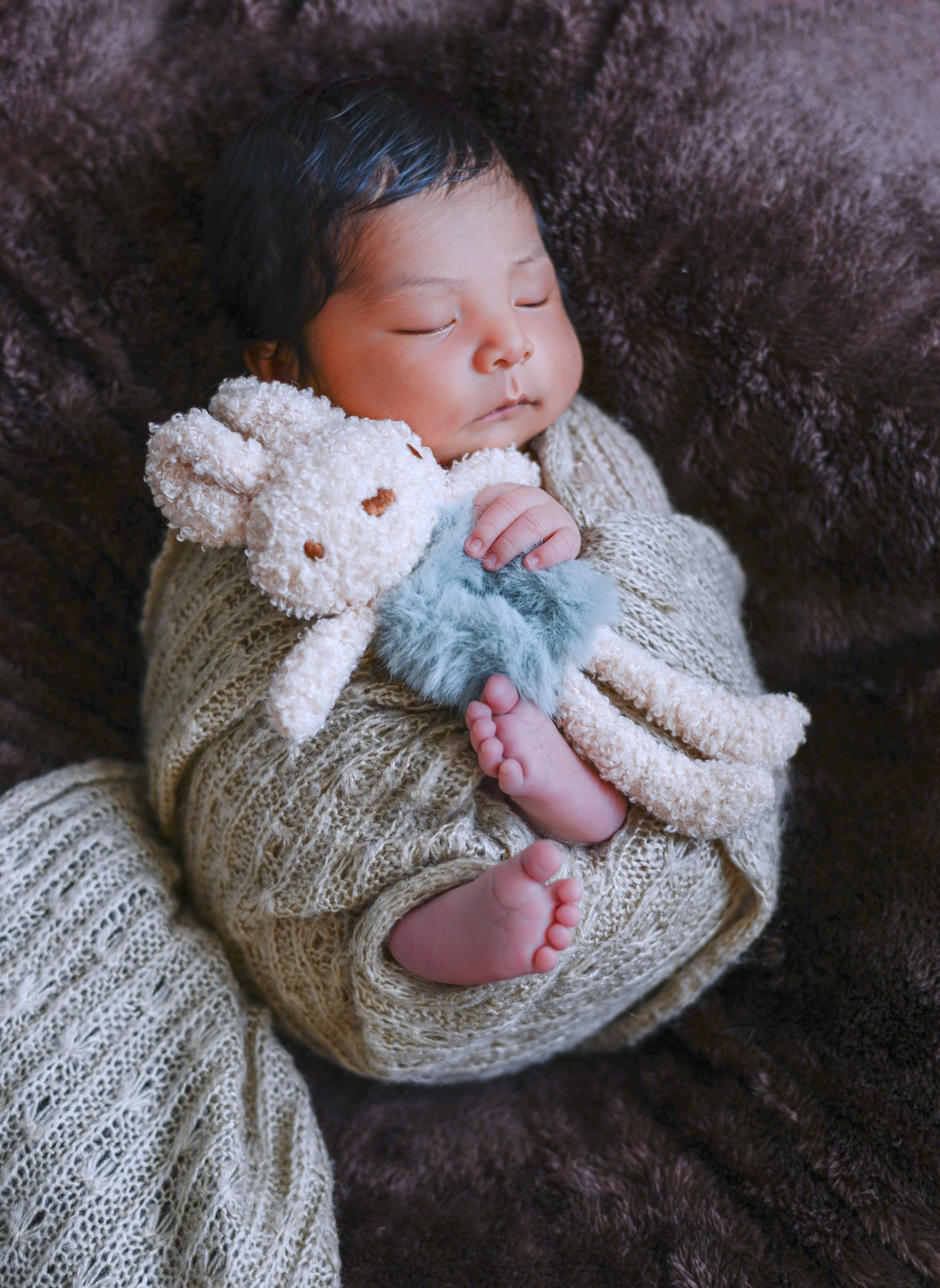Fotografía de recién nacido con gesto delicado y encuadre vertical.